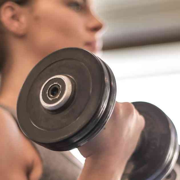 woman lifting weights in gym