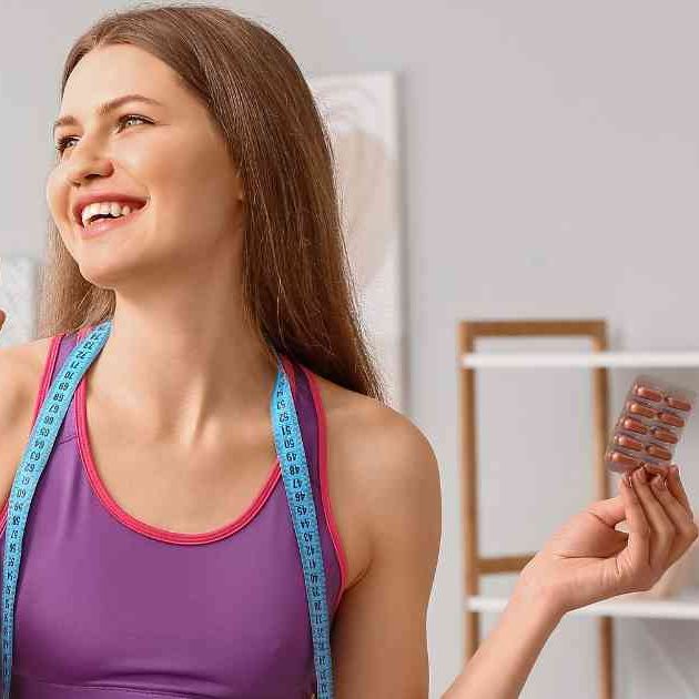 girl smiling and holding weight loss supplements