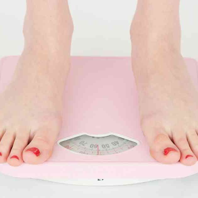 woman in bare feet standing on pink scales